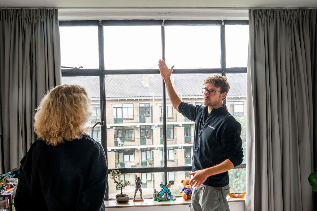 Kierenjager wijst een tochtplek aan bij een raamkozijn tijdens een training